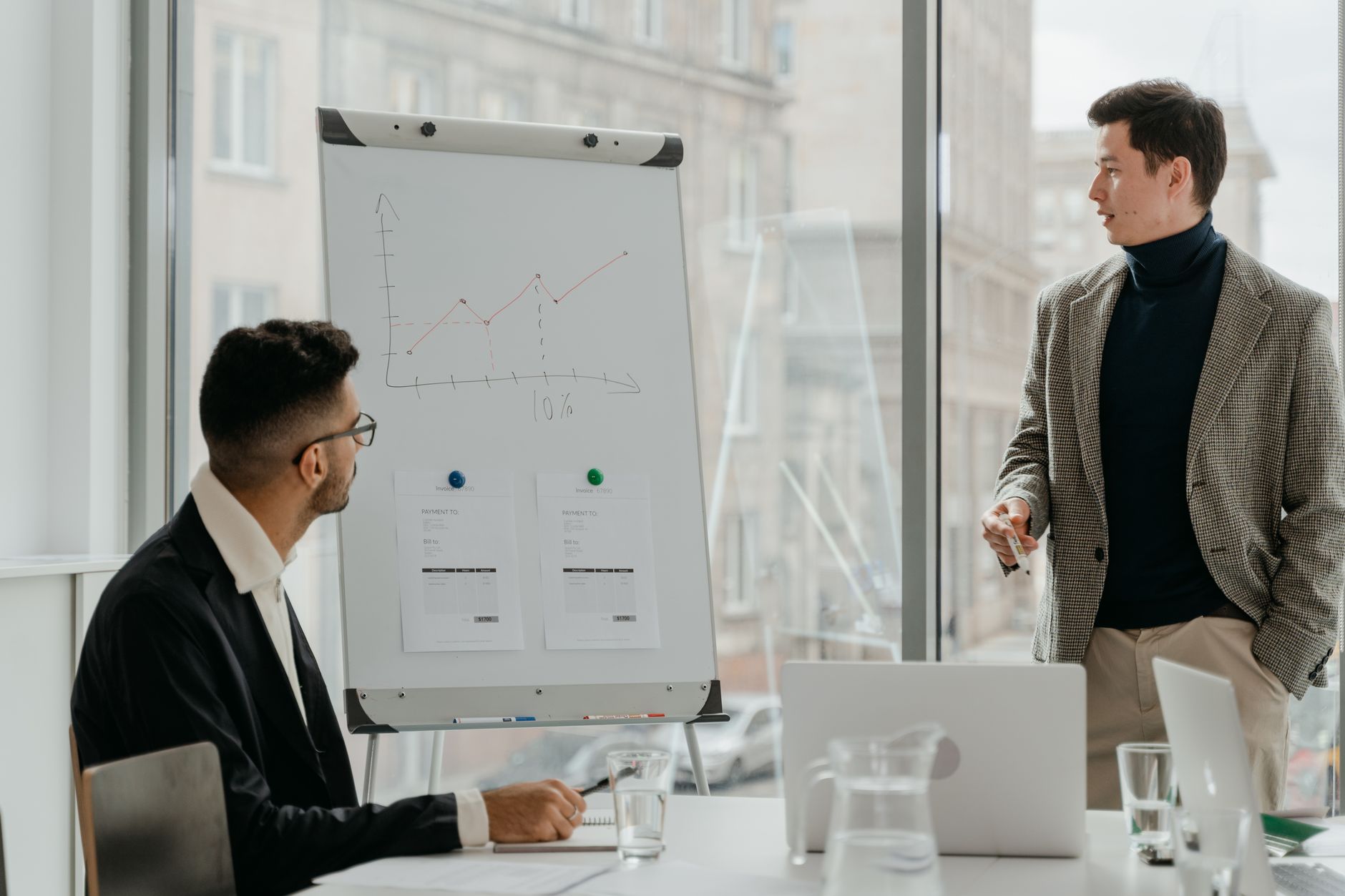 Professionals discussing a business chart in a modern office. — A Guide to position trading in Saudi Arabia