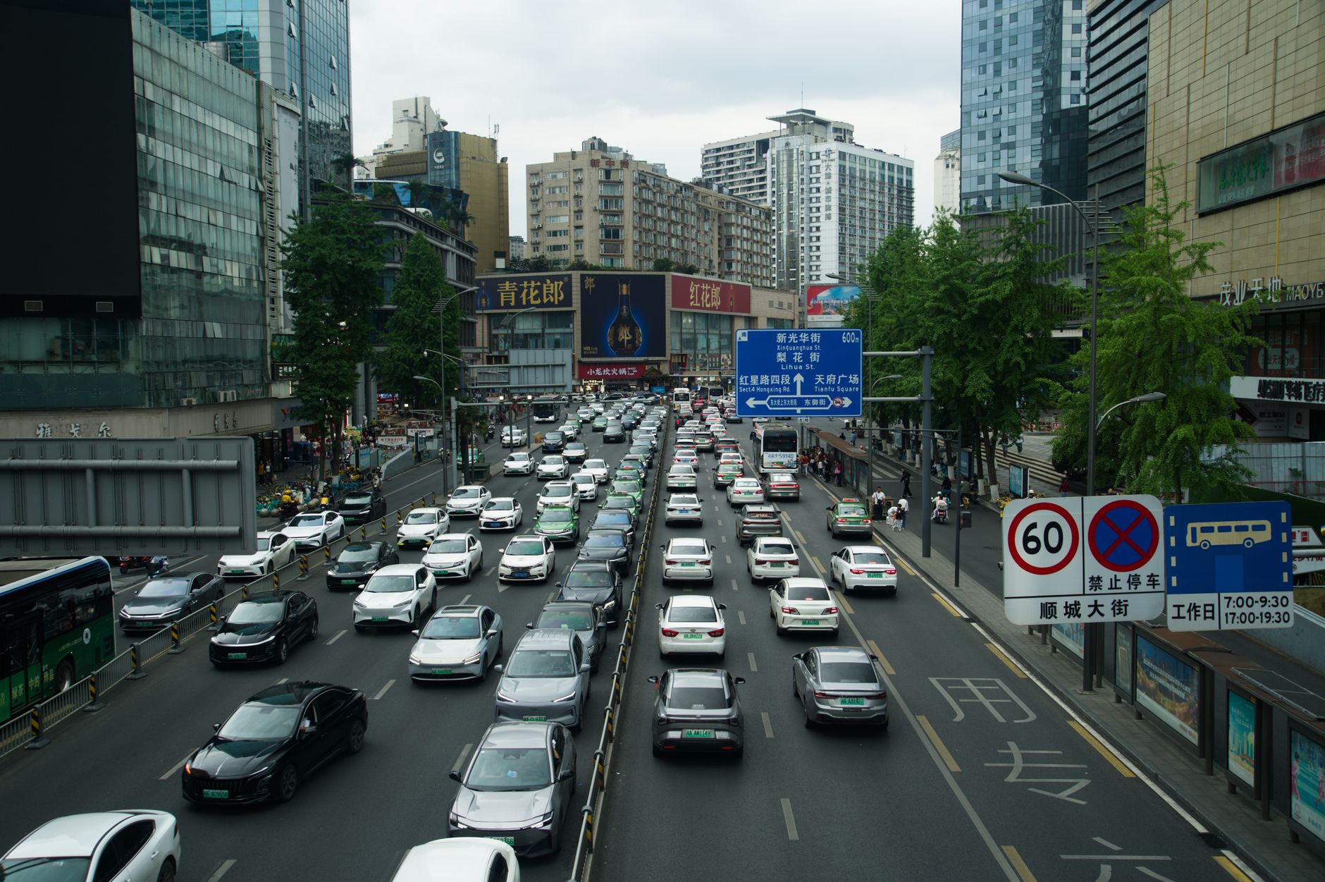 Heavy traffic on a busy Shanghai street lined with skyscrapers and billboards during the day. — Elevate Your Home Decor with