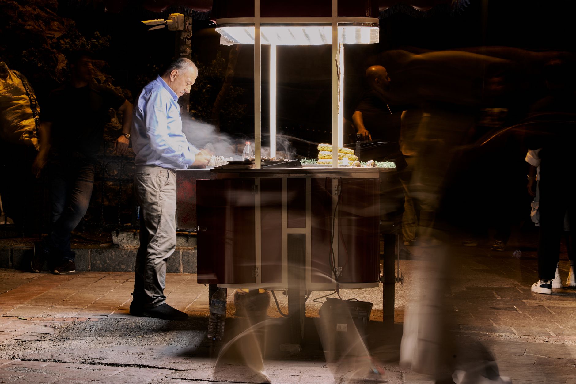 Street vendor cooking food at night with blurred people passing by. — Greater Details on Solanax Swapping Launch