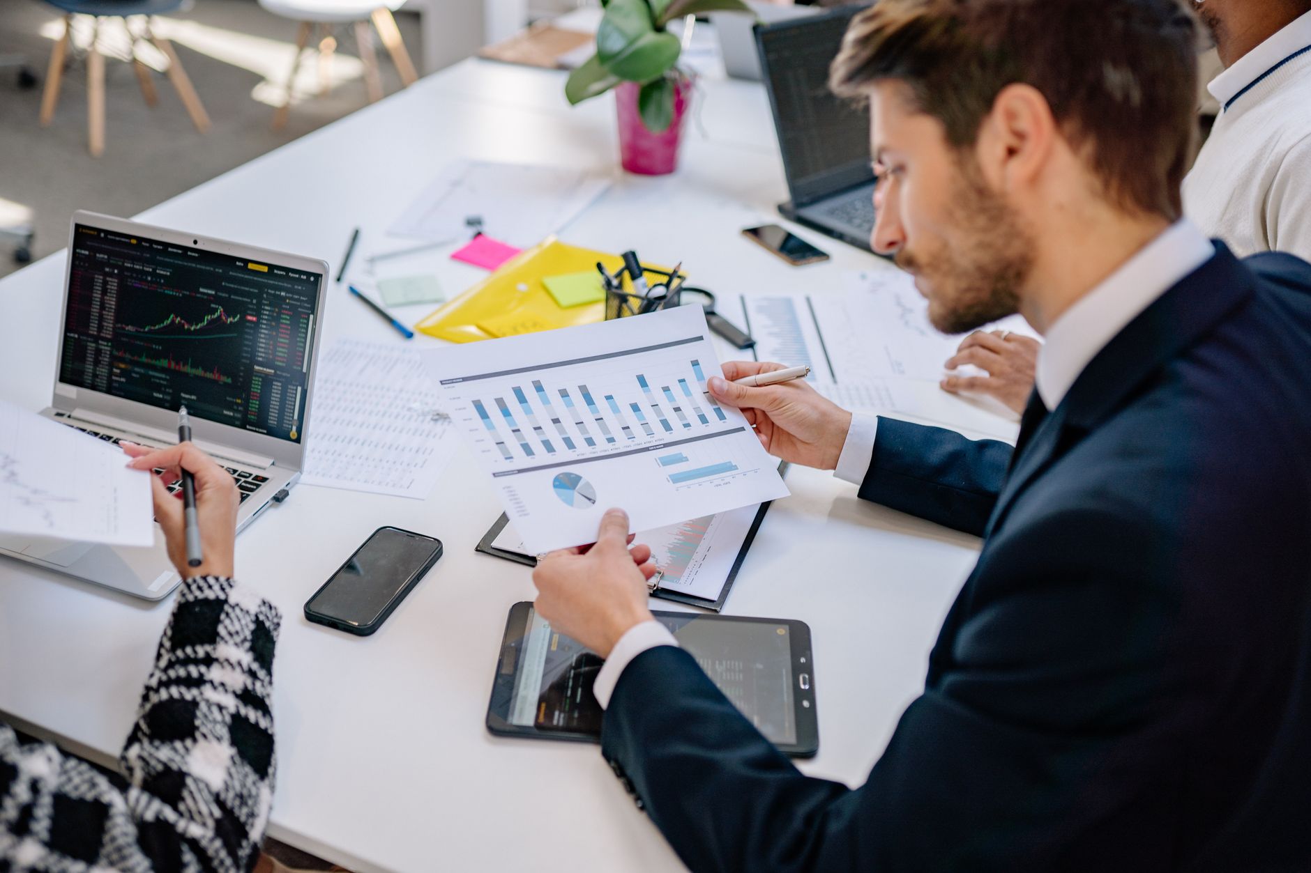 Business team reviewing graphs and data in an office setting. — Winning at Baccarat: Jeetbuzz Tips for Higher Payouts